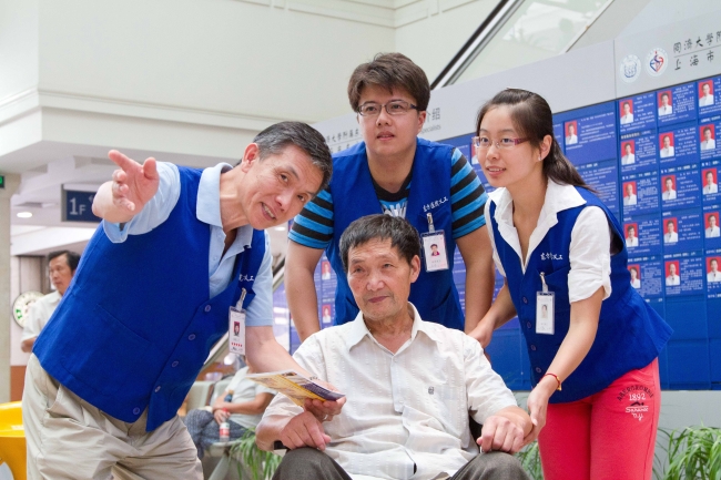 卢纪山和青年志愿者一起引导病人 卢纪山和青年志愿者一起引导病人